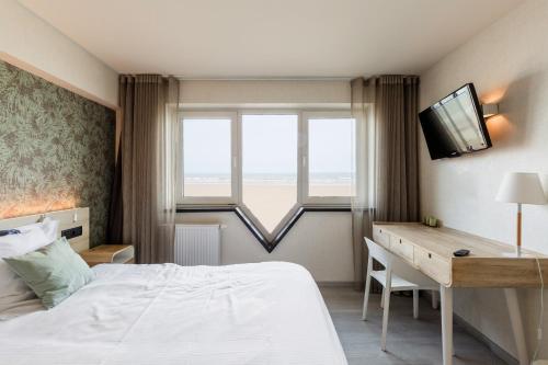 a bedroom with a bed and a desk and a television at C-Hotels Helios in Blankenberge