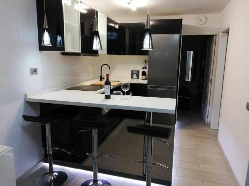 a kitchen with a white counter and black cabinets at Vistagolf Maspalomas in Maspalomas