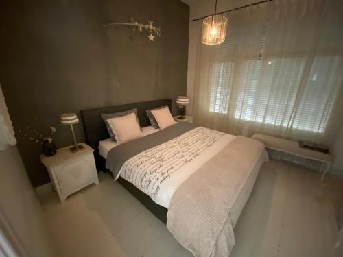 a bedroom with a large bed with white sheets and pillows at Villa Rose in Bergum