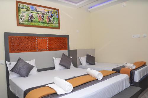 a room with two beds and a painting on the wall at HOTEL PANCHAVARNAA in Rāmeswaram