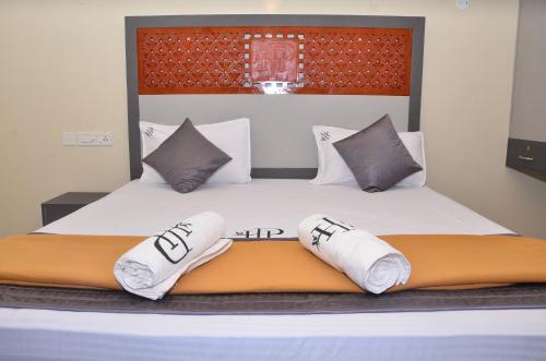 a bedroom with a bed with white sheets and pillows at HOTEL PANCHAVARNAA in Rāmeswaram