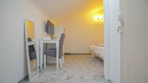 a small room with a desk and a bed at Monarch House in Braşov