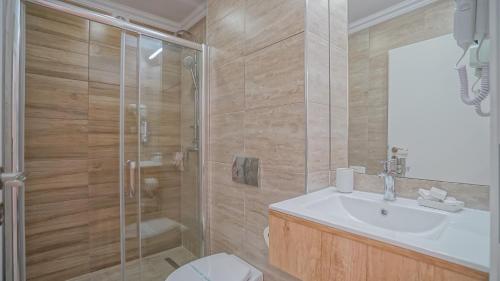 a bathroom with a shower and a sink and a toilet at Monarch House in Braşov