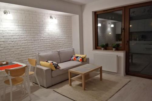 een woonkamer met een bank en een tafel bij Apartament Verona in Krynica Zdrój