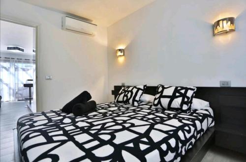 une chambre avec un lit avec des oreillers noirs et blancs dans l'établissement Vistagolf Maspalomas, à Maspalomas