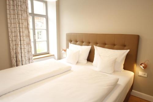 a bedroom with a bed with white sheets and a window at Amelie No 1 Hotel & Appartements in Landau in der Pfalz