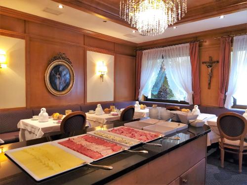 une salle à manger avec deux tables et un lustre dans l'établissement Hotel Isabella, à Merano