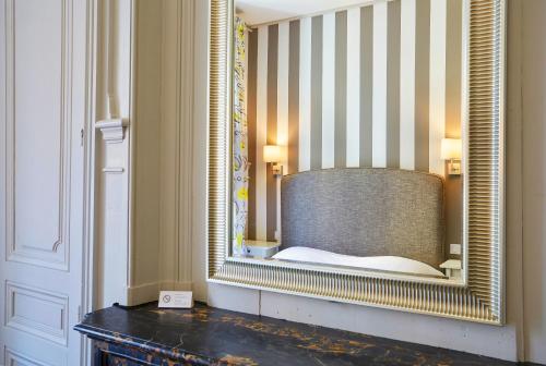 a mirror in a room with a bed in it at Hôtel Vaubecour in Lyon