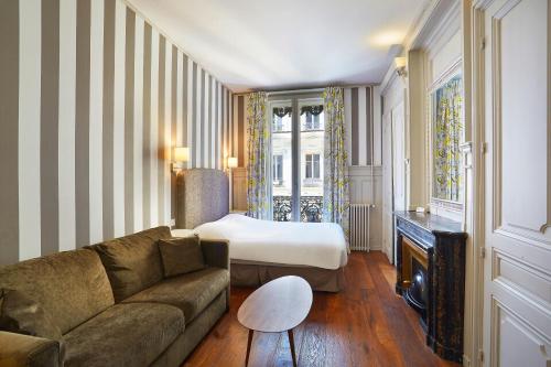 a living room with a couch and a bed at Hôtel Vaubecour in Lyon