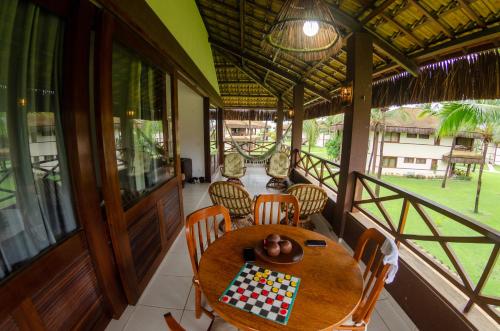 a dining room with a table with a checker board on it at Bangalô Eco Residence Flecheiras in Flecheiras