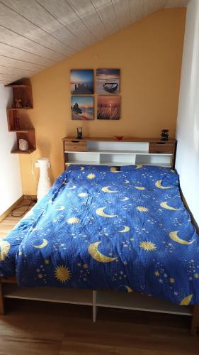 a bedroom with a bed with a blue comforter at Ferienwohnung auf dem Bückle in Kleines Wiesental