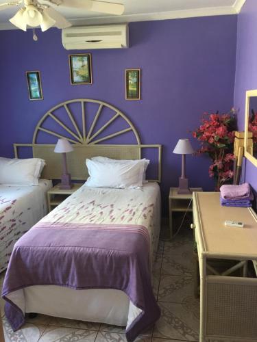 a bedroom with purple walls and a large bed at Bed and Breakfast at Eves in Durban