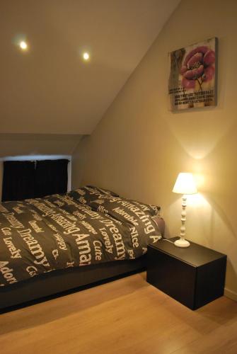 sypialnia z łóżkiem i lampką na stole w obiekcie Huisje Tybary w mieście Blankenberge