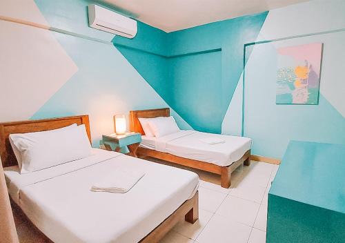 1 dormitorio con 2 camas y pared azul en The NEST, Tagaytay en Tagaytay