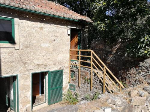 an entrance to a stone house with a wooden door at Casa do Coentral a sua casa Rustica in Lousa