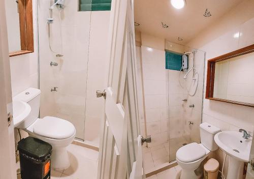 a bathroom with a toilet and a shower and a sink at The NEST, Tagaytay in Tagaytay