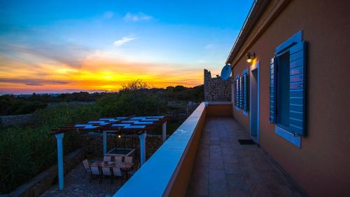 a balcony with tables and a sunset in the background at Villa Cesarica Novalja in Novalja