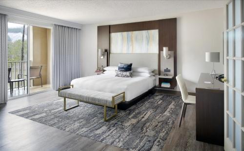 a hotel room with a bed and a desk and a desk at Atlanta Evergreen Lakeside Resort in Stone Mountain