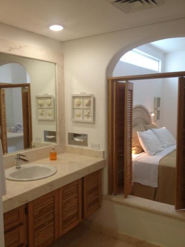a bathroom with a sink and a bed at Las Villas Akumal in Akumal