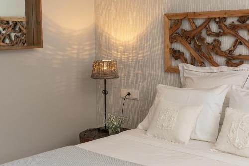 a bedroom with a bed with white pillows and a lamp at Charming Villa Golf & Beach in Cascais
