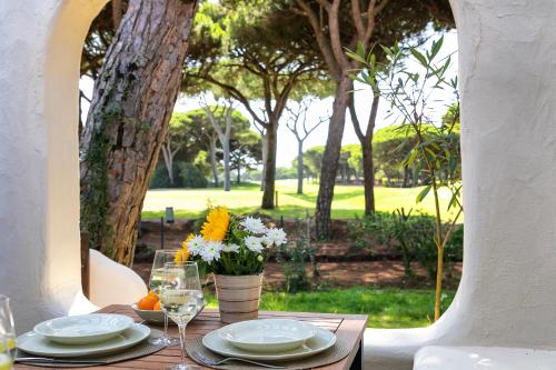 a table with plates and glasses and a vase of flowers at Charming Villa Golf & Beach in Cascais