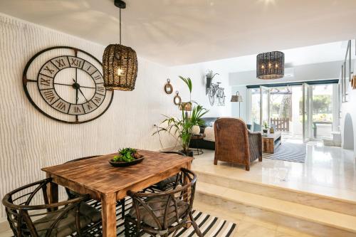 a dining room with a large clock on the wall at Charming Villa Golf & Beach in Cascais