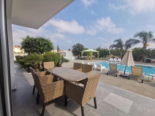 a patio with a table and chairs and a pool at Royal Sugar in Ayia Napa