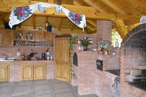 a kitchen with a brick oven and a brick wall at Pensiunea Malinul in Bîrsana