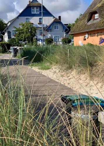 a beach with tall grass and houses and a building at Strandhaus WOTAN in Kühlungsborn