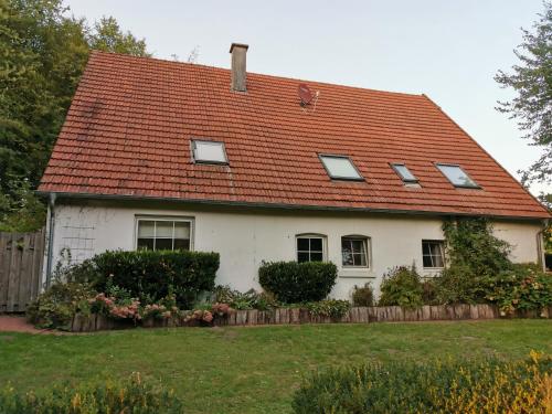 une maison blanche avec un toit rouge dans l'établissement Gästehaus Alte Liebe, à Borgholzhausen