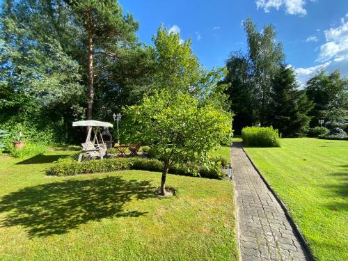 a garden with a tree in the grass at Strandhaus WOTAN in Kühlungsborn