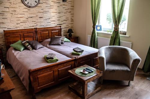 a bedroom with a bed and a chair and a clock at Apartament w Drawsku in Drawsko Pomorskie