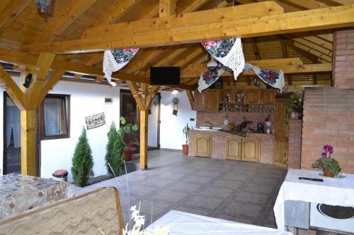 Bîrsana的住宿－Pensiunea Malinul，户外厨房和用餐区,拥有木制天花板