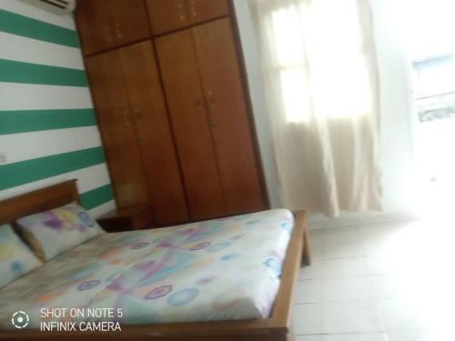 een slaapkamer met een bed, een kast en een raam bij Residences Hotels Sejours Affaires in Abidjan