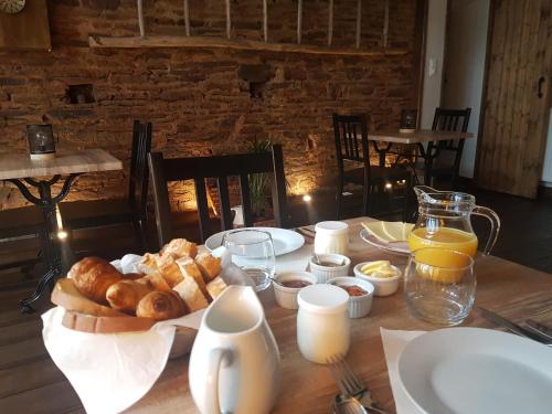 una mesa con un plato de pan y zumo de naranja en La Bastide Du Bonheur Chambres et Tables D'Hôtes, en Ger