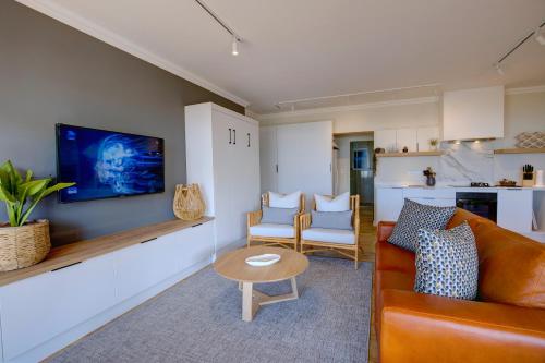 a living room with a couch and a table at Oppiesee Selfcatering Apartments in Herolds Bay