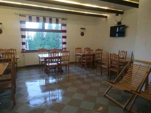 un comedor con mesas y sillas y una ventana en Оселя Драгобрат en Dragobrat