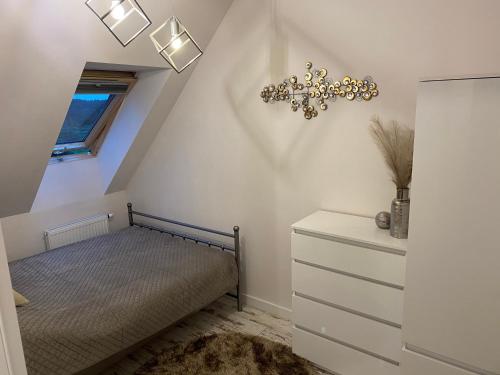 a bedroom with a bed and a chandelier at GOJA in Sztutowo