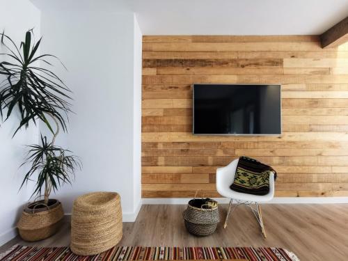 a living room with a wooden wall with a tv at Oroel in Jaca