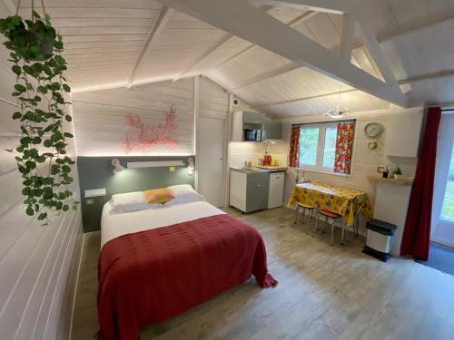 a bedroom with a bed and a table in a room at Le Cabanon de Chessy in Chessy