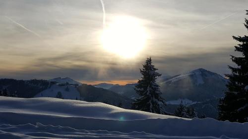 a sun is setting over a snow covered mountain at Résidence Julianna , trajets remontées mécaniques , livraison viennoiseries, piscine couverte in Morzine