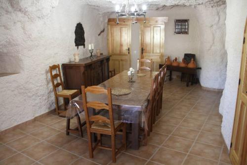 una cucina e una sala da pranzo con tavolo e sedie di CUEVAS AL ANDALUS - Solea a Orce