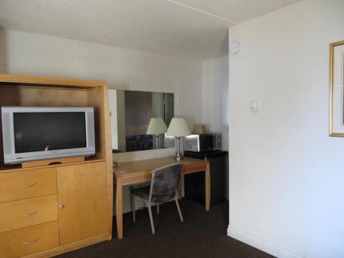 a hotel room with a desk with a tv and a deskictericter at Eastglen Inn in Edmonton