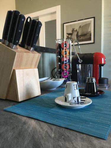 a kitchen counter with a table with a blue table cloth at Pellico Stylish Apartments in Cuneo