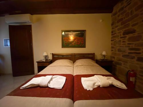 a bedroom with a bed with two towels on it at Archontiko Riziko in Kambos