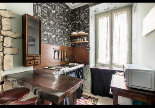 eine Küche mit einem Holztisch und einem Waschbecken in der Unterkunft django apartament in Rom