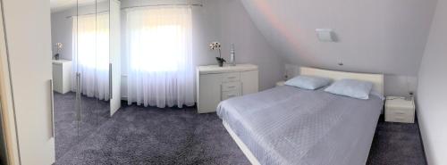 a white bedroom with a bed and a window at Apartament Lilianna in Ustroń