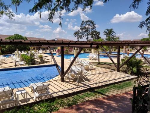 a wooden deck with chairs and a swimming pool at Winterville Flat 213 in Gravatá