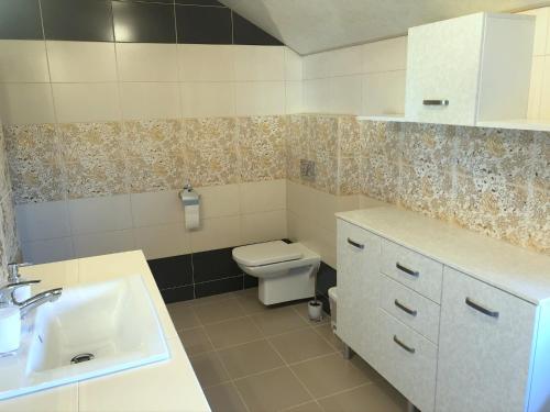 a bathroom with a white sink and a toilet at Apartament Lilianna in Ustroń