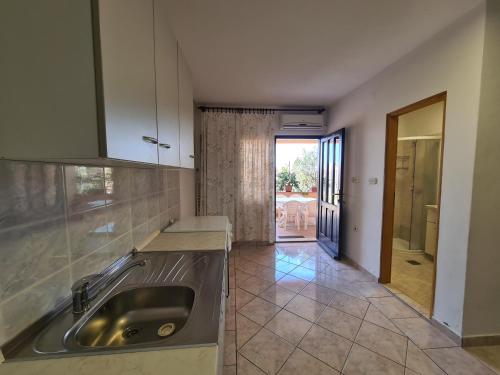 a kitchen with a sink and a door to a patio at Apartments Barbati in Kustići